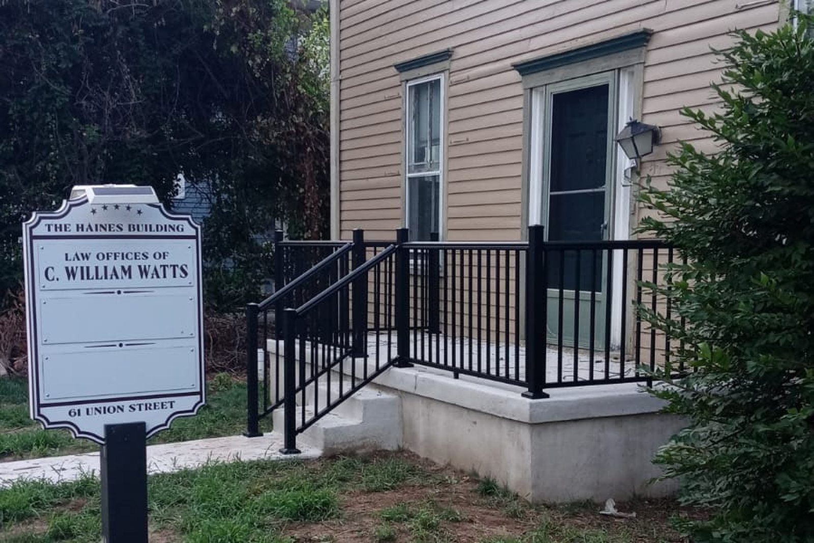 A commercial building with a new railing and entrance walkway